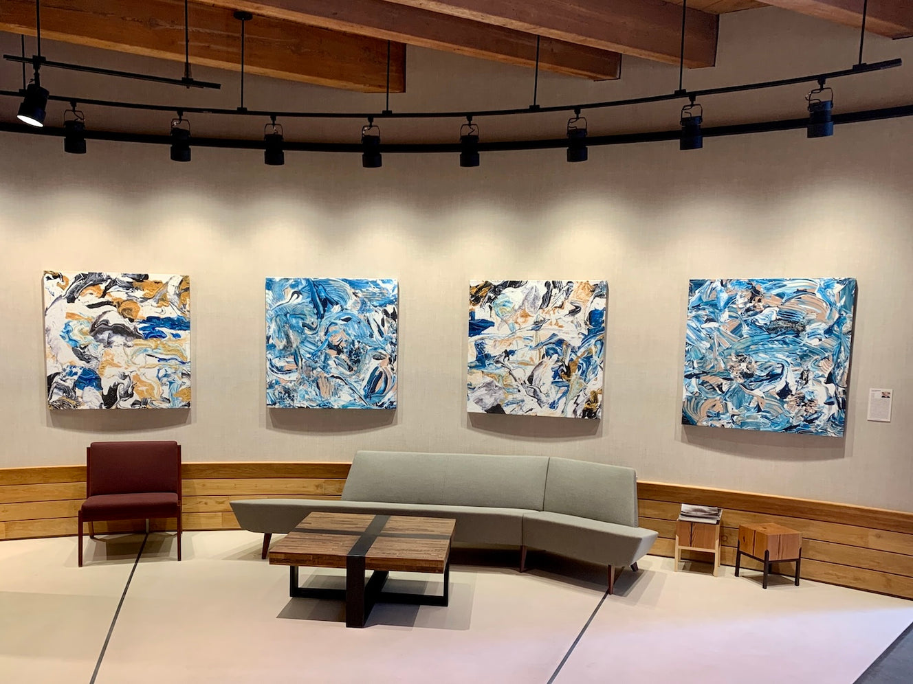  At 313 Congress Street, this inviting lobby area features four print reproductions by ArtLifting artist Billy Megargel, whose expressive, layered compositions in blues, whites, and neutrals convey a sense of movement and depth that complements the room’s natural textures and modern furnishings. 
