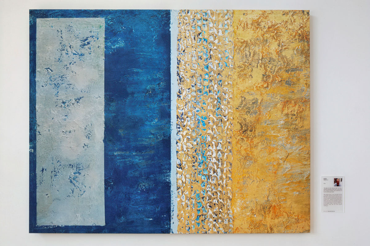 Abstract art piece with blue and yellow sections on a white wall.