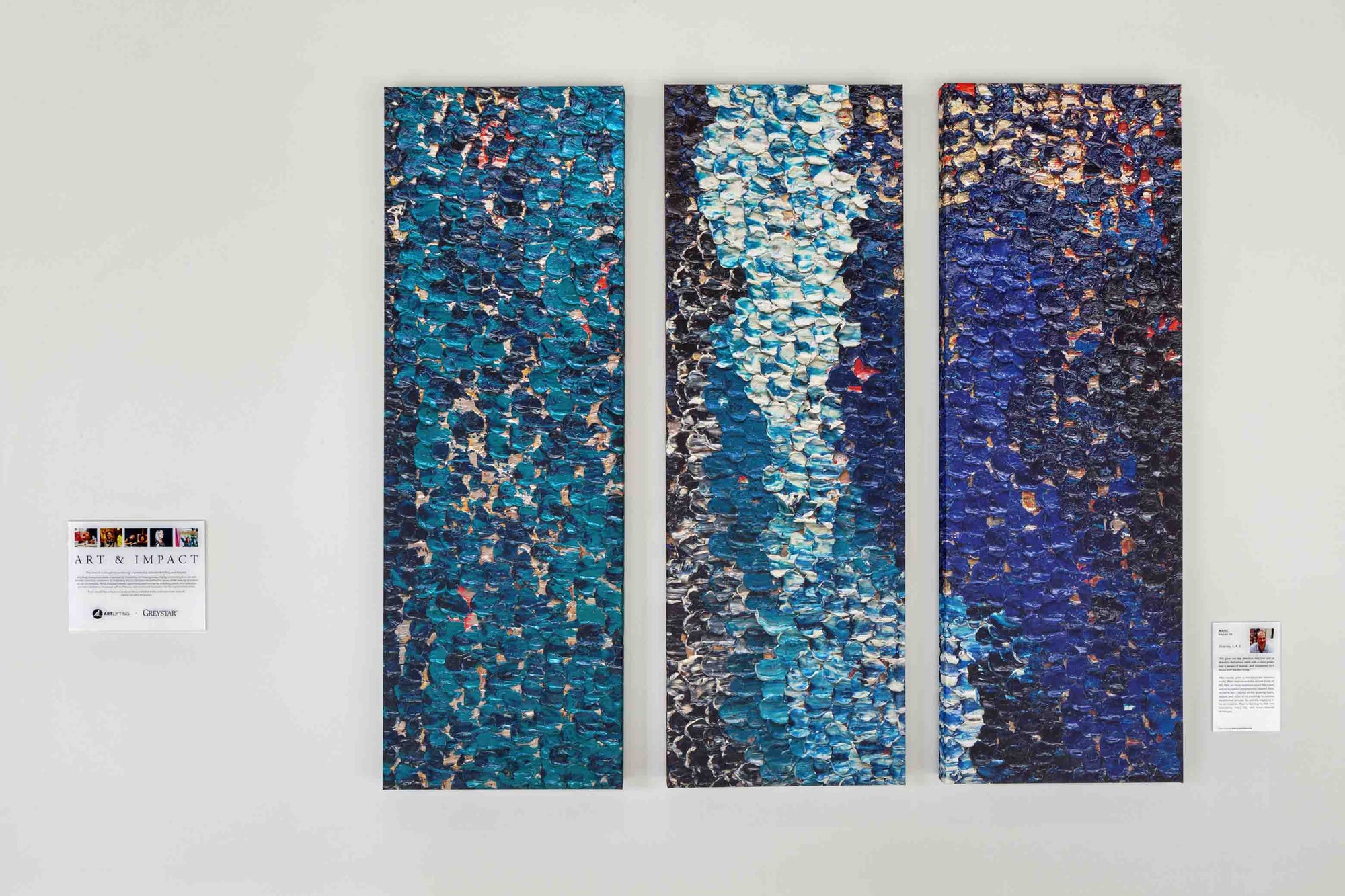 Three abstract art panels hanging on a wall.
