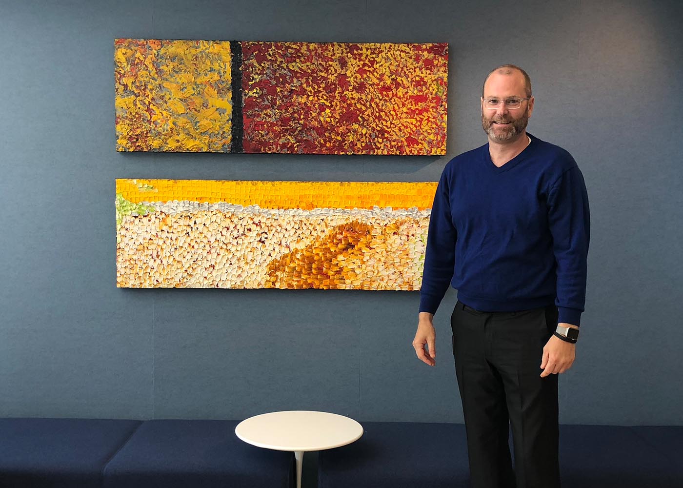 Man standing in front of abstract art on a gray wall